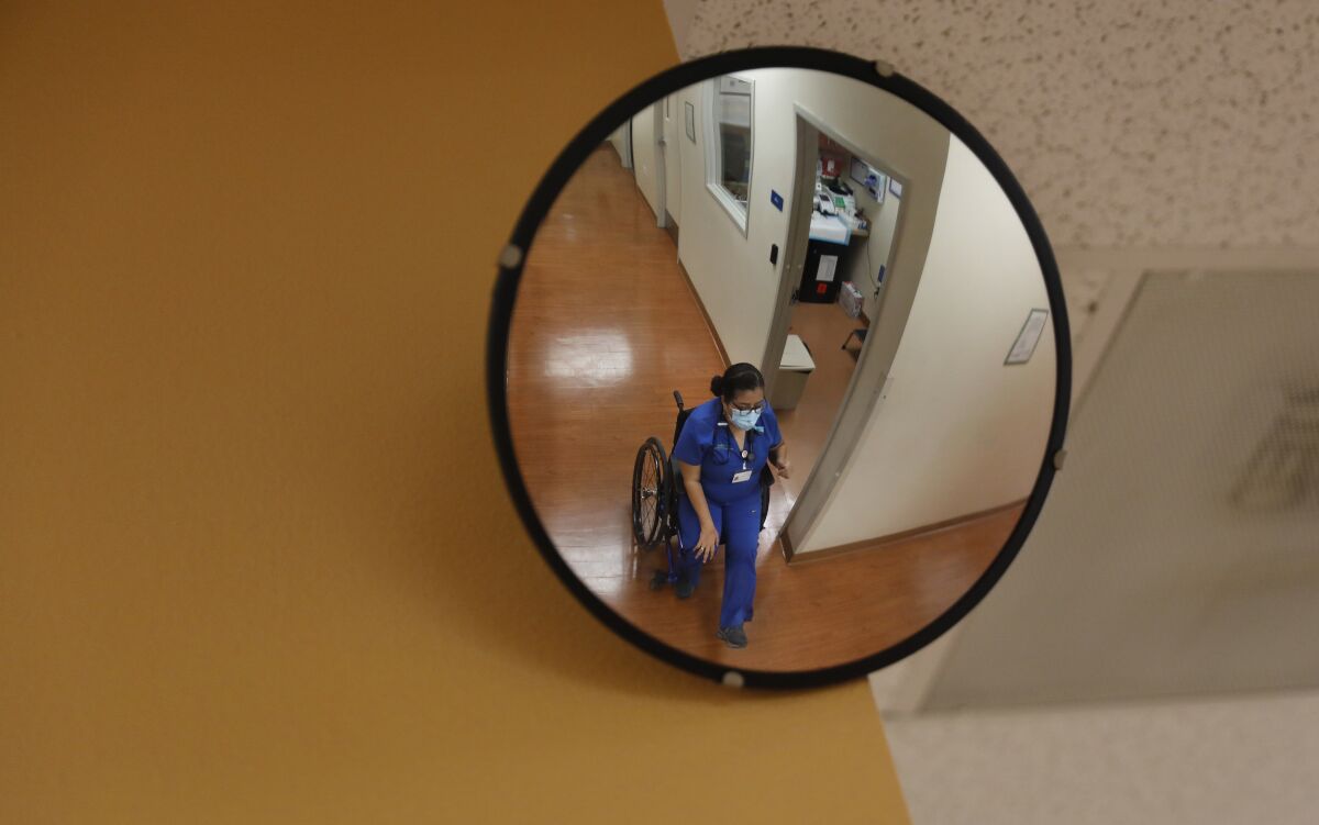 Physician Marie Flores makes her way down the hall while seeing patients at an AltaMed clinic in Pico Rivera.