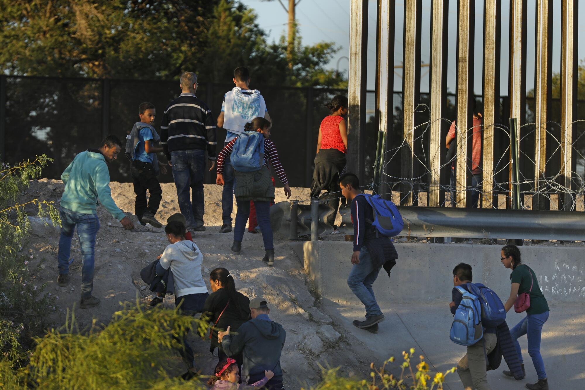 Migrantes cruzan de Juárez, México, a El Paso, donde agentes de la Patrulla Fronteriza esperan para detenerlos.