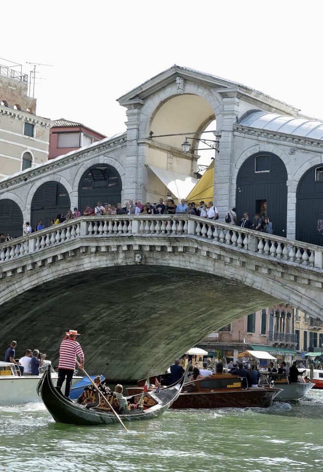 Gawkers on Venice's Rialto Bridge watch as George Clooney, Amal Alamuddin, Cindy Crawford and Rande Gerber pass under them.