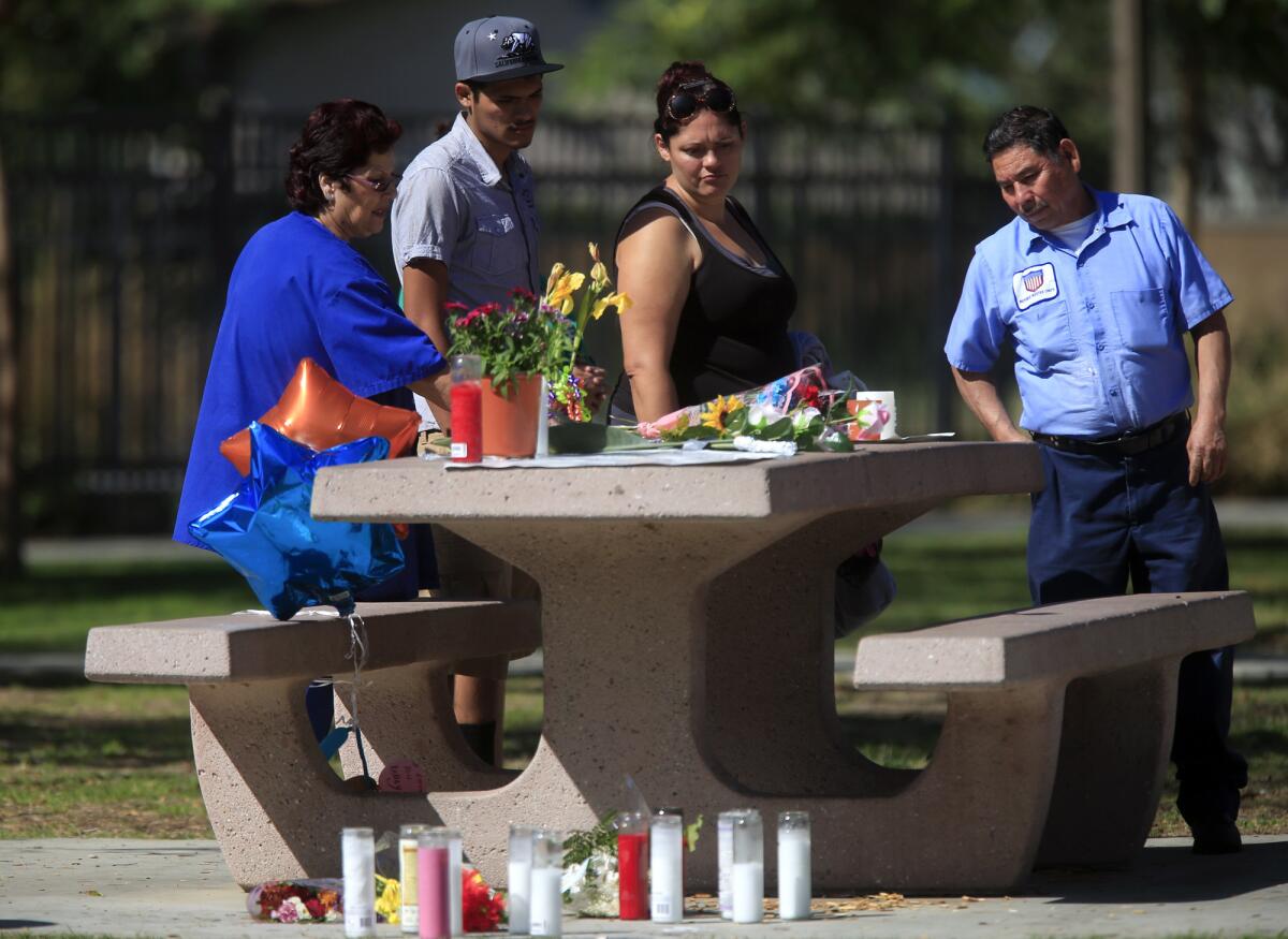 Neighbors check on a makeshift memorial for Kellye Taylor at Orizaba Park in Long Beach in October 2013.