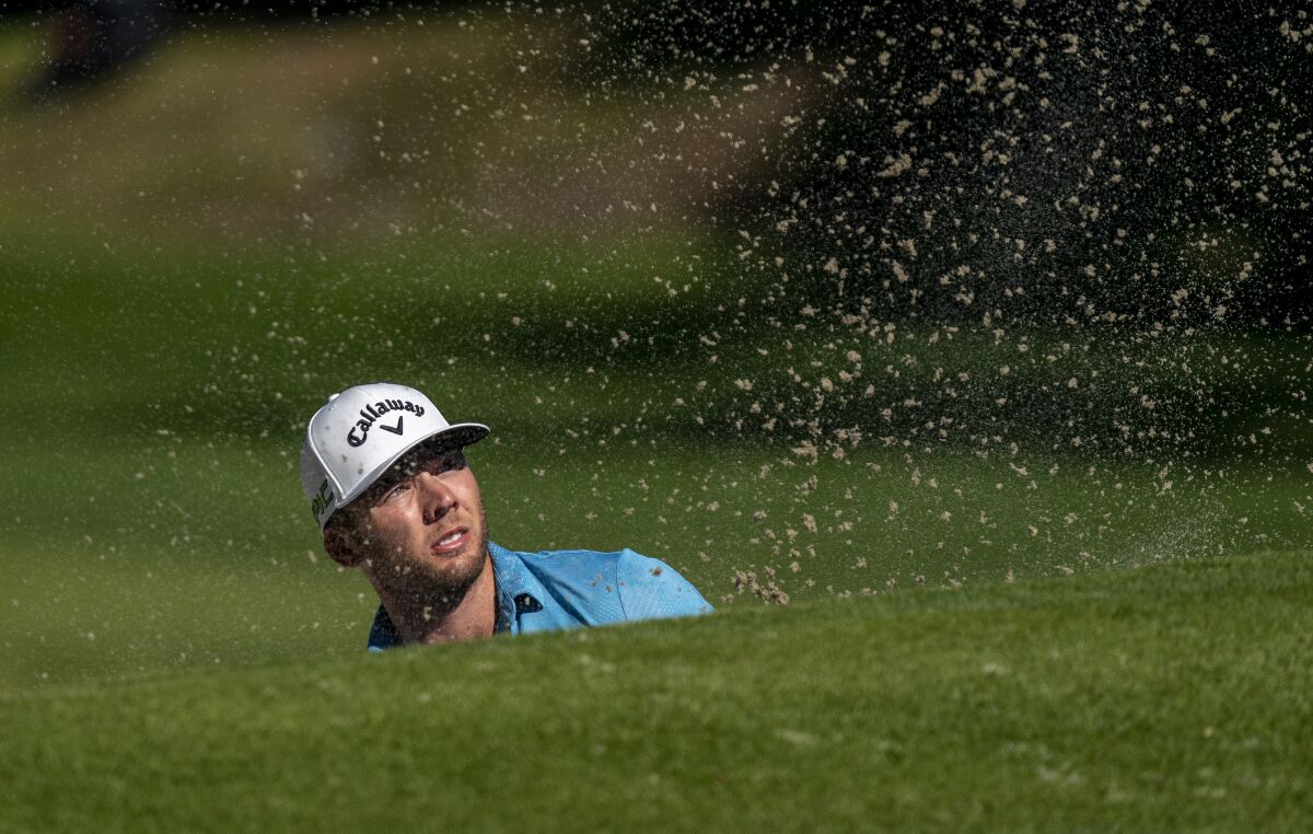 Sam Burns watches the flight of his ball after he sprayed shot from a greenside bunker.