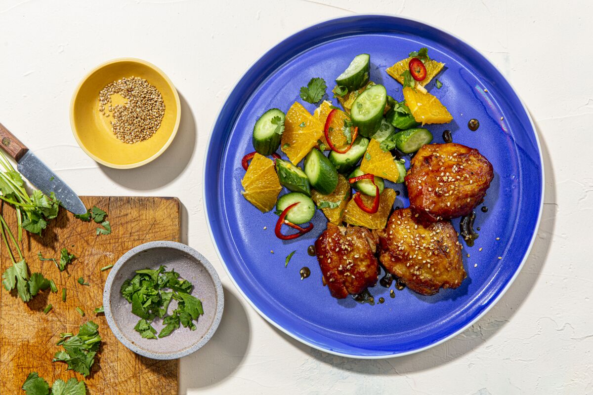 Sticky chicken thighs with orange and cucumber salad.