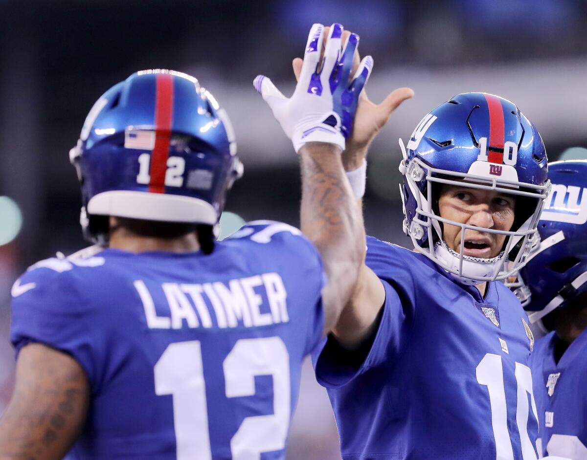 New York Giants quarterback Eli Manning, right, celebrates with teammate Cody Latimer after teammate Bennie Fowler III ran the ball in for a touchdown in the first quarter against the Chicago Bears during a preseason game on Friday in East Rutherford, N.J.