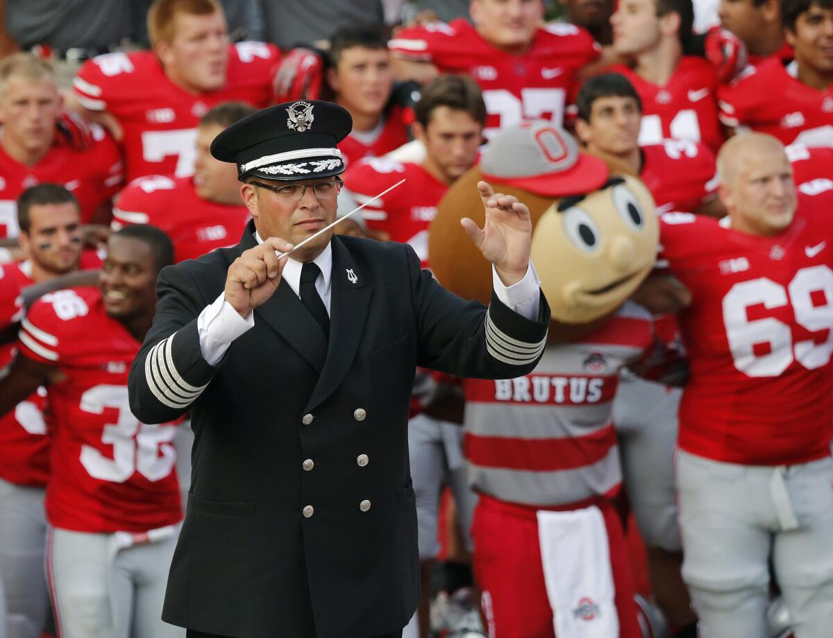 In this 2013 photo, Ohio State University marching band director Jonathan Waters leads the band in "Carmen Ohio" after an NCAA football game against San Diego State at Ohio Stadium in Columbus, Ohio.
