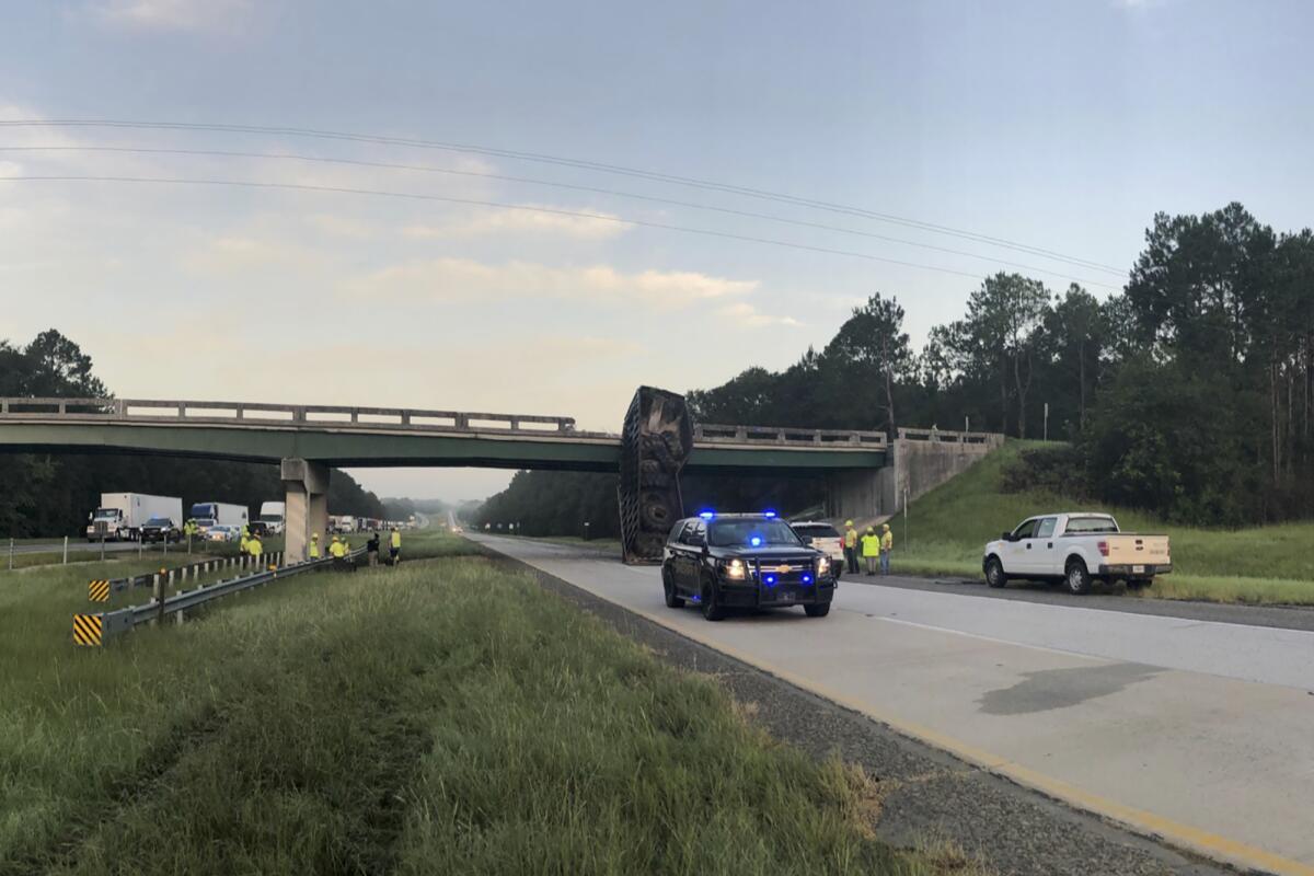 In this photo released by the Georgia Department of Transportation, the SR 86 bridge is inspected over Interstate 16 in Treutlen County, Ga., Thursday, July 15, 2021. The Interstate is shut down in both directions from Exit 71 to Exit 78 due to a large dump trailer hitting the SR 86 bridge and shifting it nearly six feet. (GDOT via AP)