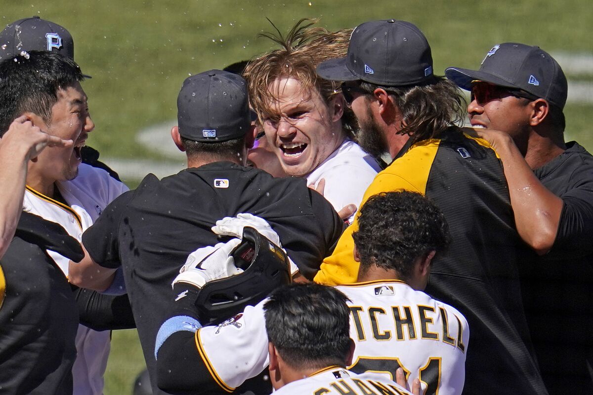 Pittsburgh Pirates' Jack Suwinski, center, is swarmed by teammates after hitting a walkoff solo home run off San Francisco Giants relief pitcher Tyler Rogers during the ninth inning of a baseball game in Pittsburgh, Sunday, June 19, 2022. It was Suwinski's third solo home run of the game. (AP Photo/Gene J. Puskar)