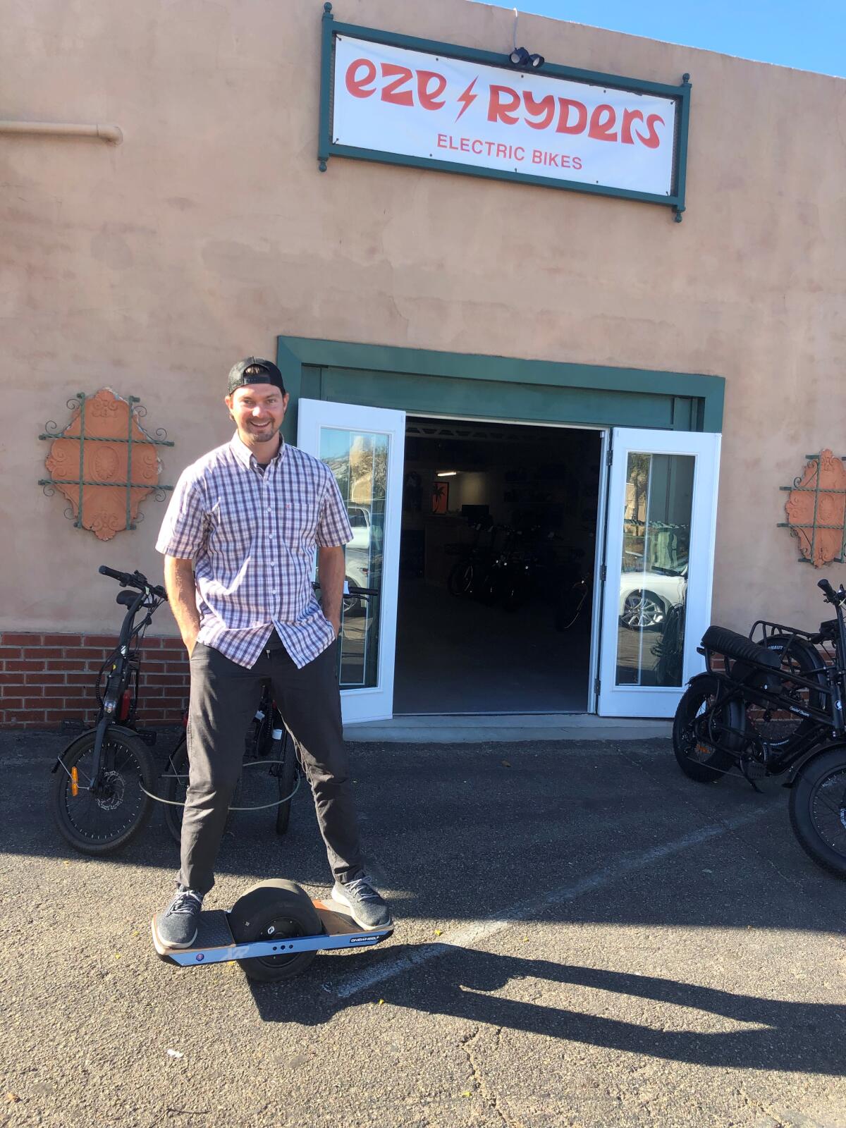 Devin Raymond rolls up outside his new electric bicycle shop, EZE Ryders in Point Loma.