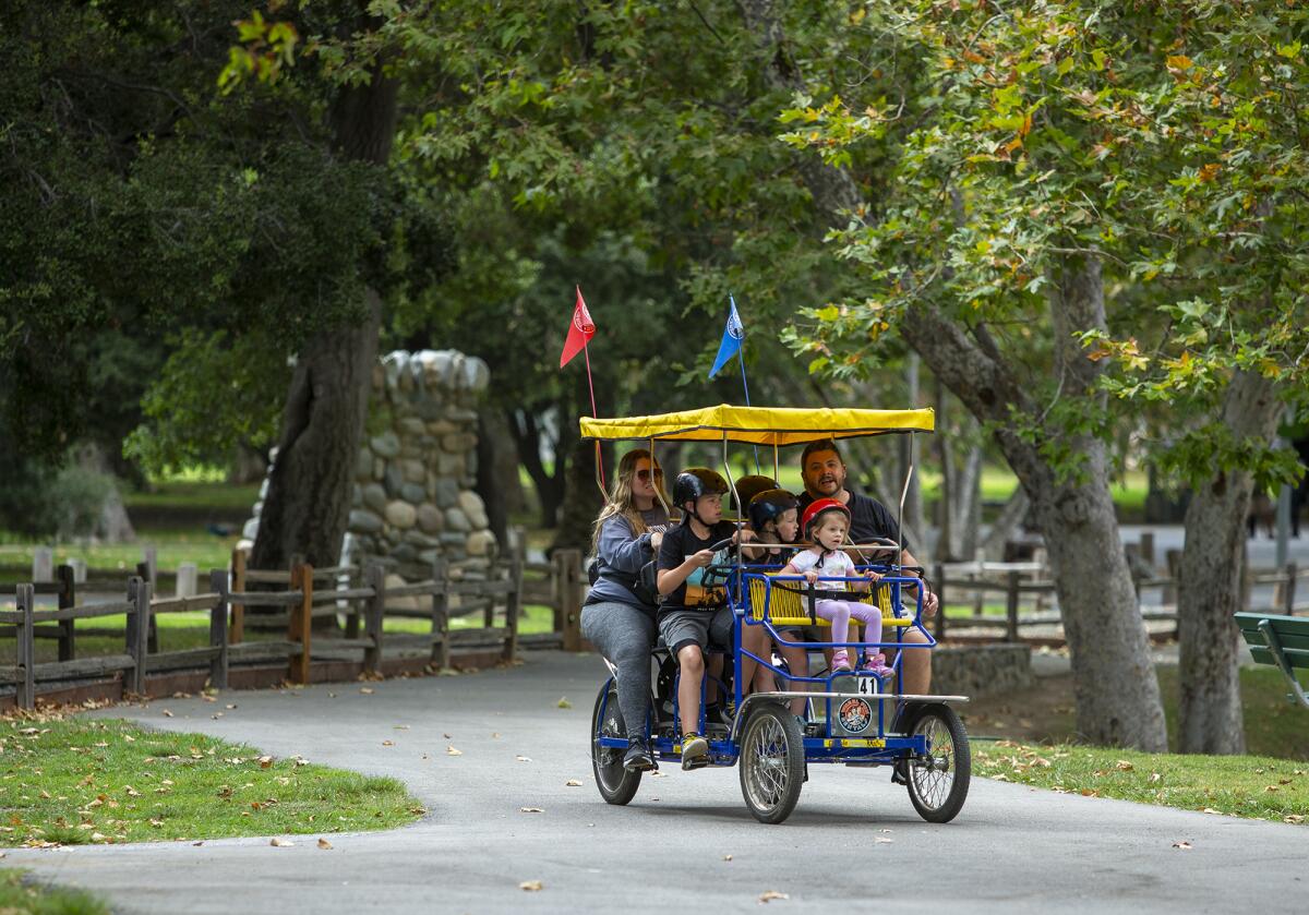 A family rides a rental pedal bike at the Irvine Regional Park.