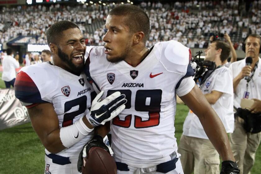 Arizona receiver Austin Hill (29) celebrates with a teammate after catching a game-winning, 47-yard touchdown pass against California on Sept. 20, 2014.