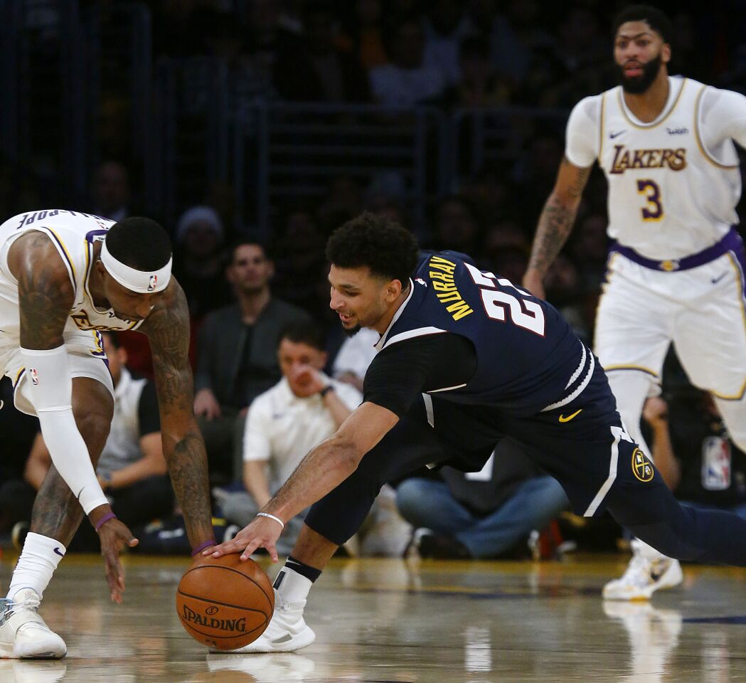 Lakers guard Kentavious Caldwell-Pope, left, battles for a loose ball with Nuggets guard Jamal Murray during the second quarter.