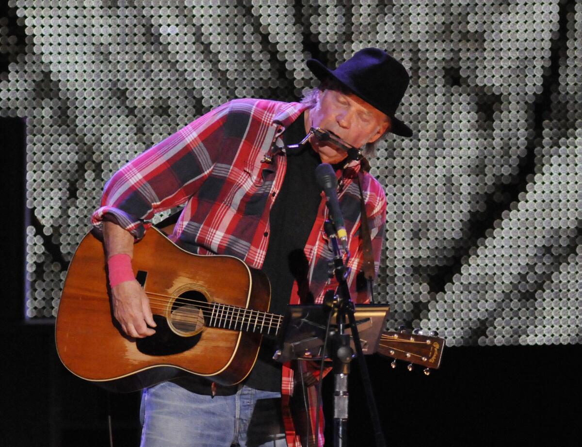 Neil Young, shown during the Farm Aid 2013 concert in New York on Sept. 21, will reunite with David Crosby, Stephen Stills and Graham Nash for the 27th Bridge School Benefit concert on Oct. 26-27 in Mountain View, Calif.