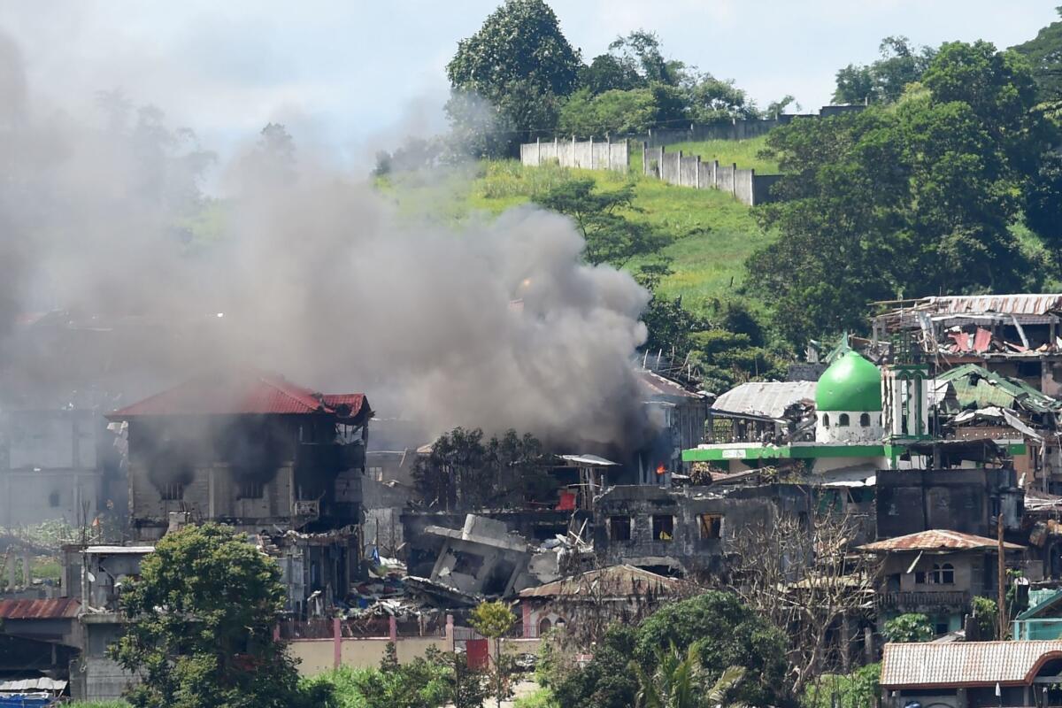 Smoke billows from houses set alight by mortar fire as fighting between government troops and Islamist militants continues in Marawi on the southern island of Mindanao, June 26, 2017.