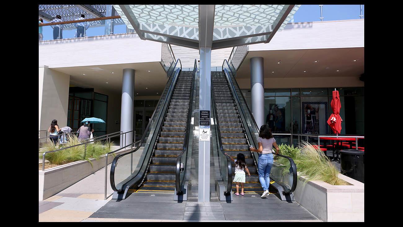 A woman and a little girl go up the just-opened escalators leading to the brand new dinning terrace at the Burbank Town Center mall, in Burbank on Thursday, Aug. 16, 2018.
