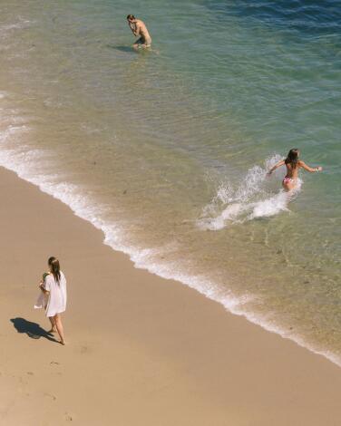Beach goers walk along the Aliso Beach and play in the water. (Allen J. Schaben / Los Angeles Times)