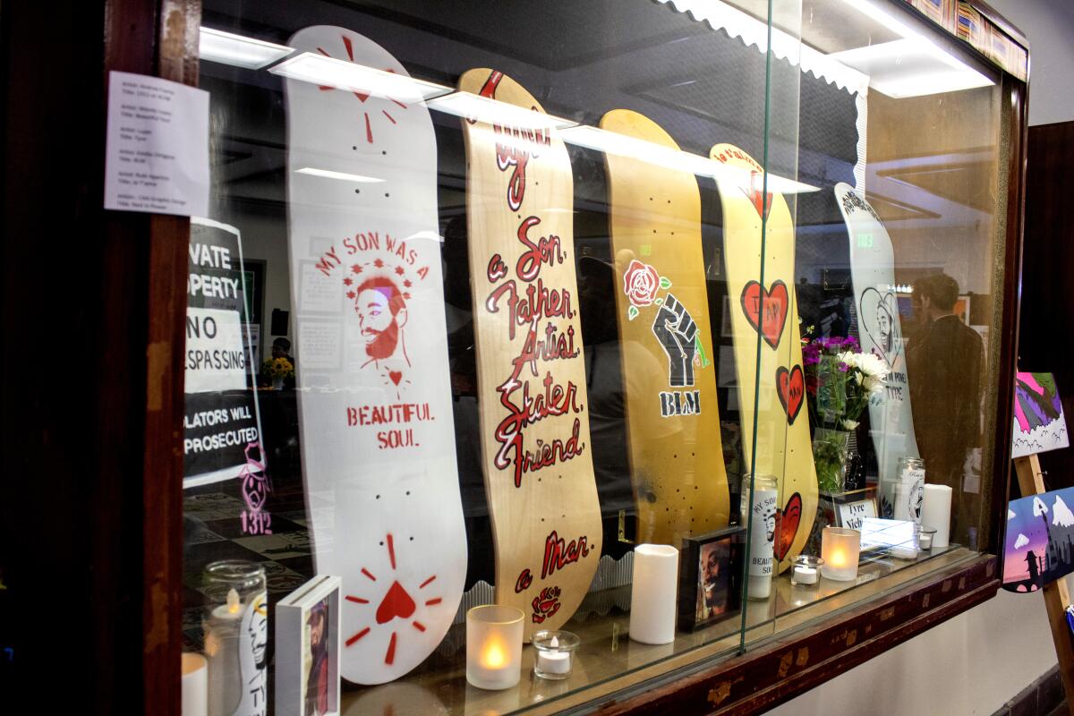 Five skateboards in a glass-front display case.