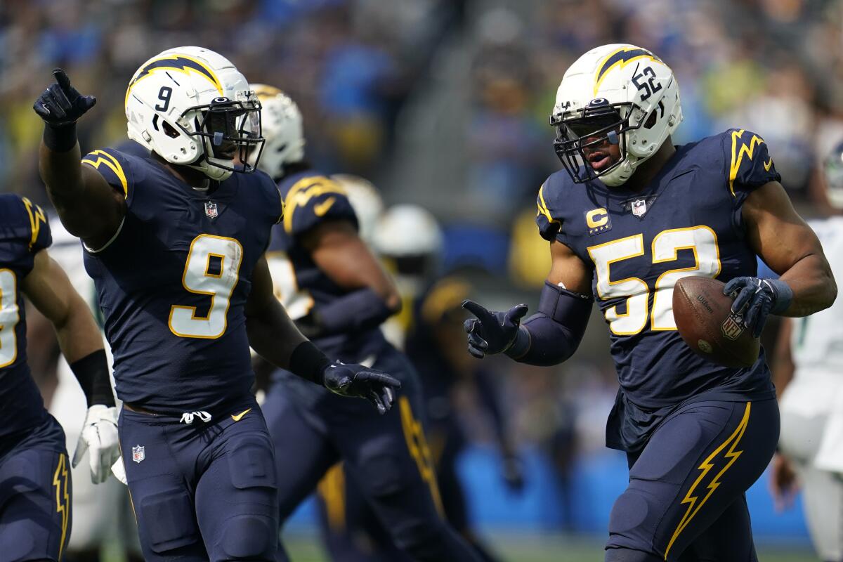 Chargers linebacker Khalil Mack (52) celebrates with Kenneth Murray Jr. after recovering a fumble against Seattle.