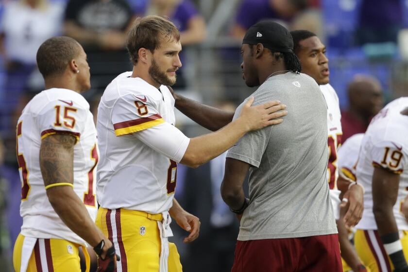 Kirk Cousins (8) greets Robert Griffin III before Washington's preseason game against Baltimore on Saturday.