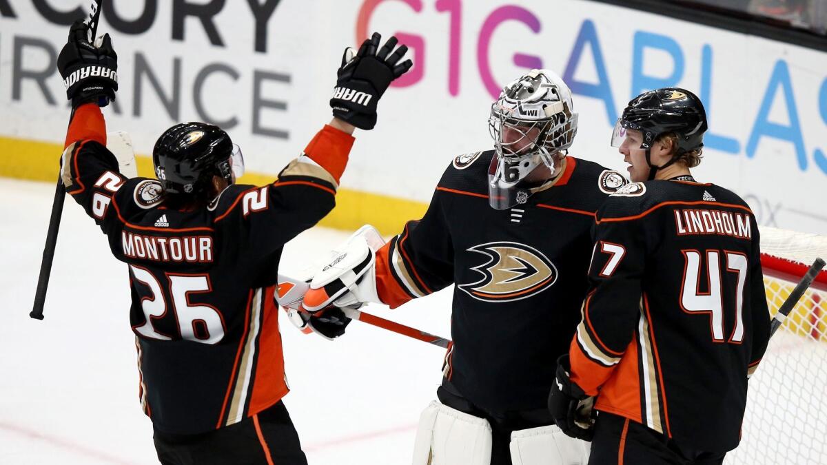 Brandon Montour and Hampus Lindholm congratulate Ducks goalie John Gibson after he shut out the Washington Capitals on March 6..