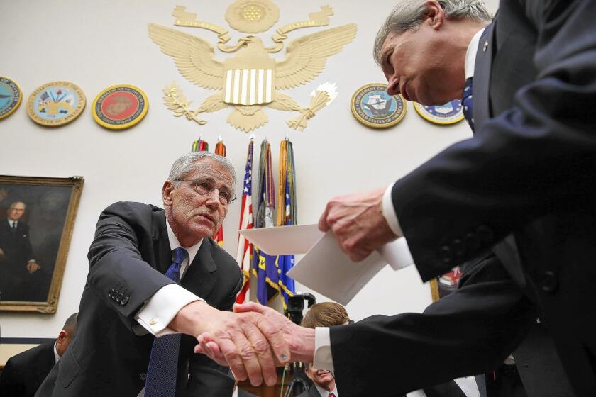 Defense Secretary Chuck Hagel greets members of the House Armed Services Committee during a break in testimony.