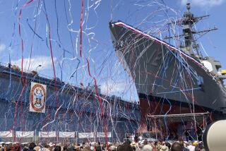 Streamers are shot in the air as a future U.S. Navy destroyer bearing the name of Medal of Honor recipient Barney Barnum is christened at Bath Iron Works on Saturday, July 29, 2023, in Bath, Maine. (AP Photo/David Sharp)