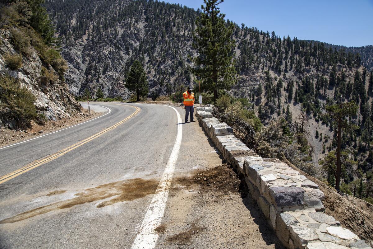 A Caltrans worker stands near the site of a fatal crash on Angeles Crest Highway.