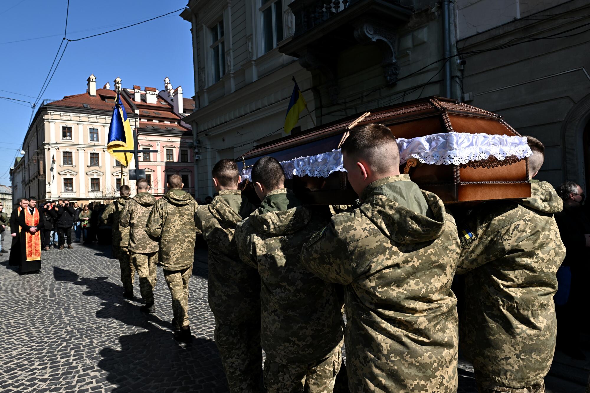 Ukrainian soldiers carry the casket of a comrade during a funeral outside the Church of St. Peter and Paul in Lviv, Ukraine