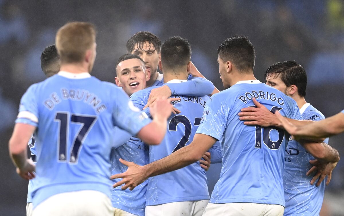 Manchester City's Phil Foden, centre, celebrates after scoring his side's opening goal during the English Premier League soccer match between Manchester City and Brighton and Hove Albion at the Etihad Stadium in Manchester, England, Wednesday, Jan. 13, 2021. (Laurence Griffiths, Pool via AP)
