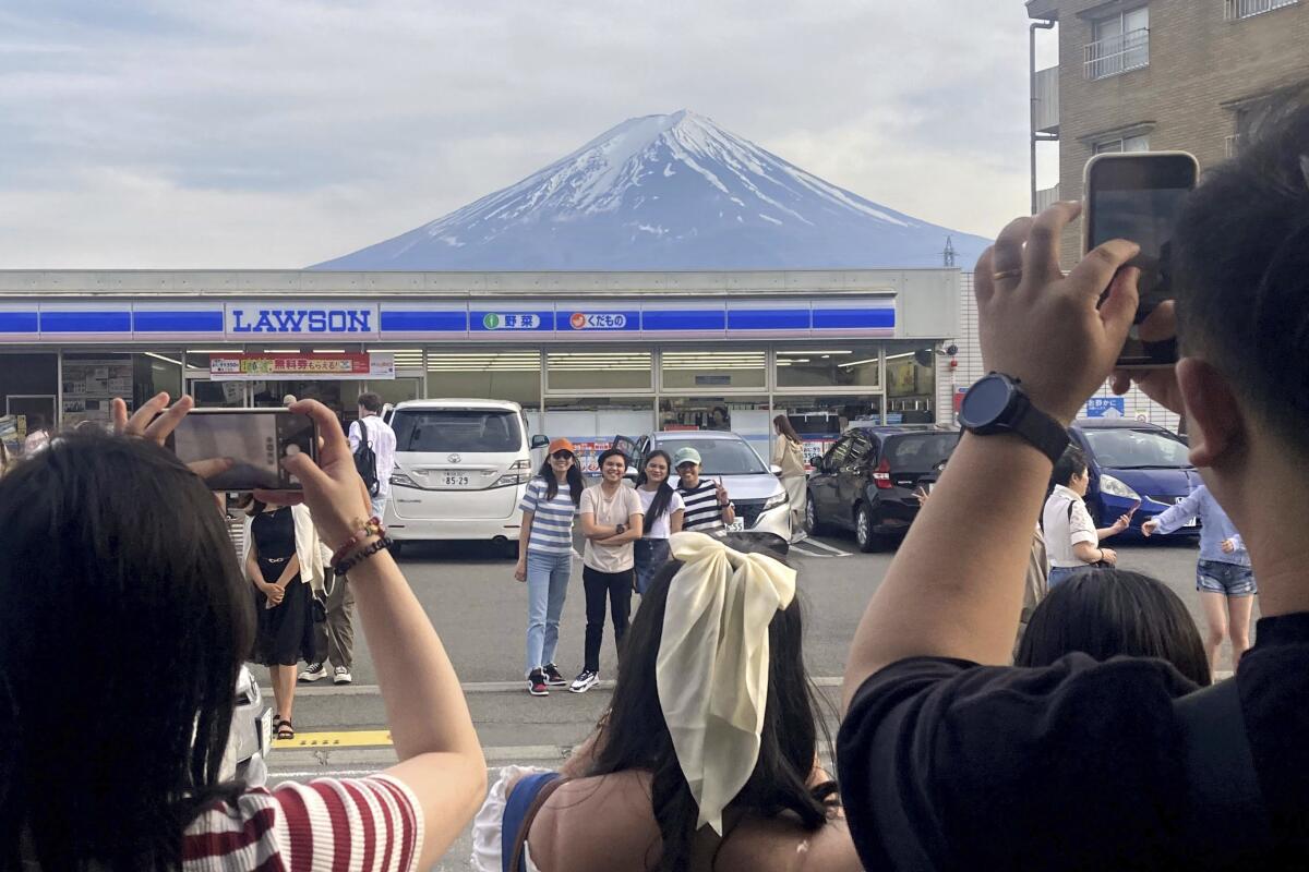 Visitors take photos of Mt. Fuji in the town of Fujikawaguchiko, Japan.