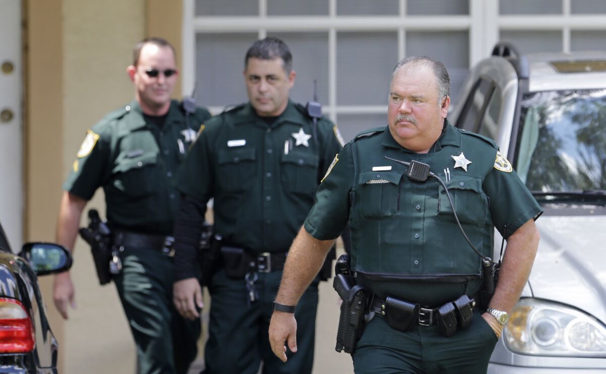 Port St. Lucie County sheriff's officers leave the Fort Pierce, Fla., property owned by the family of Seddique Mateen, the father of Pulse nightclub shooter Omar Mateen.