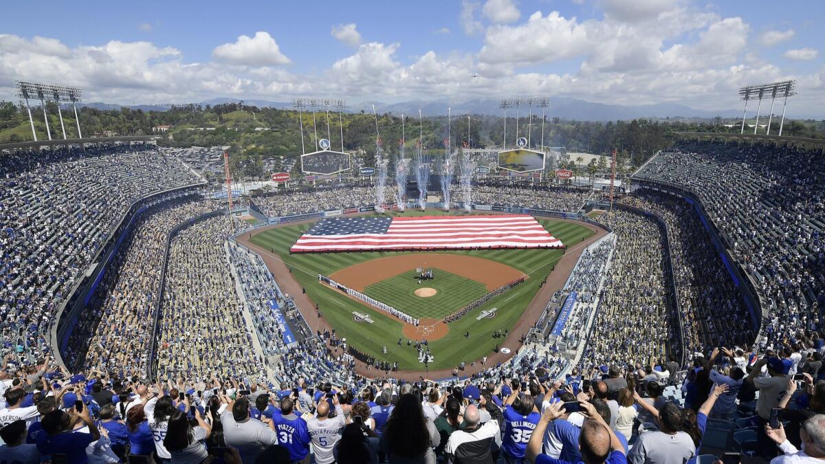 Fans stand for the national anthem before the Dodgers' season opener against the Arizona Diamondbacks on March 28.