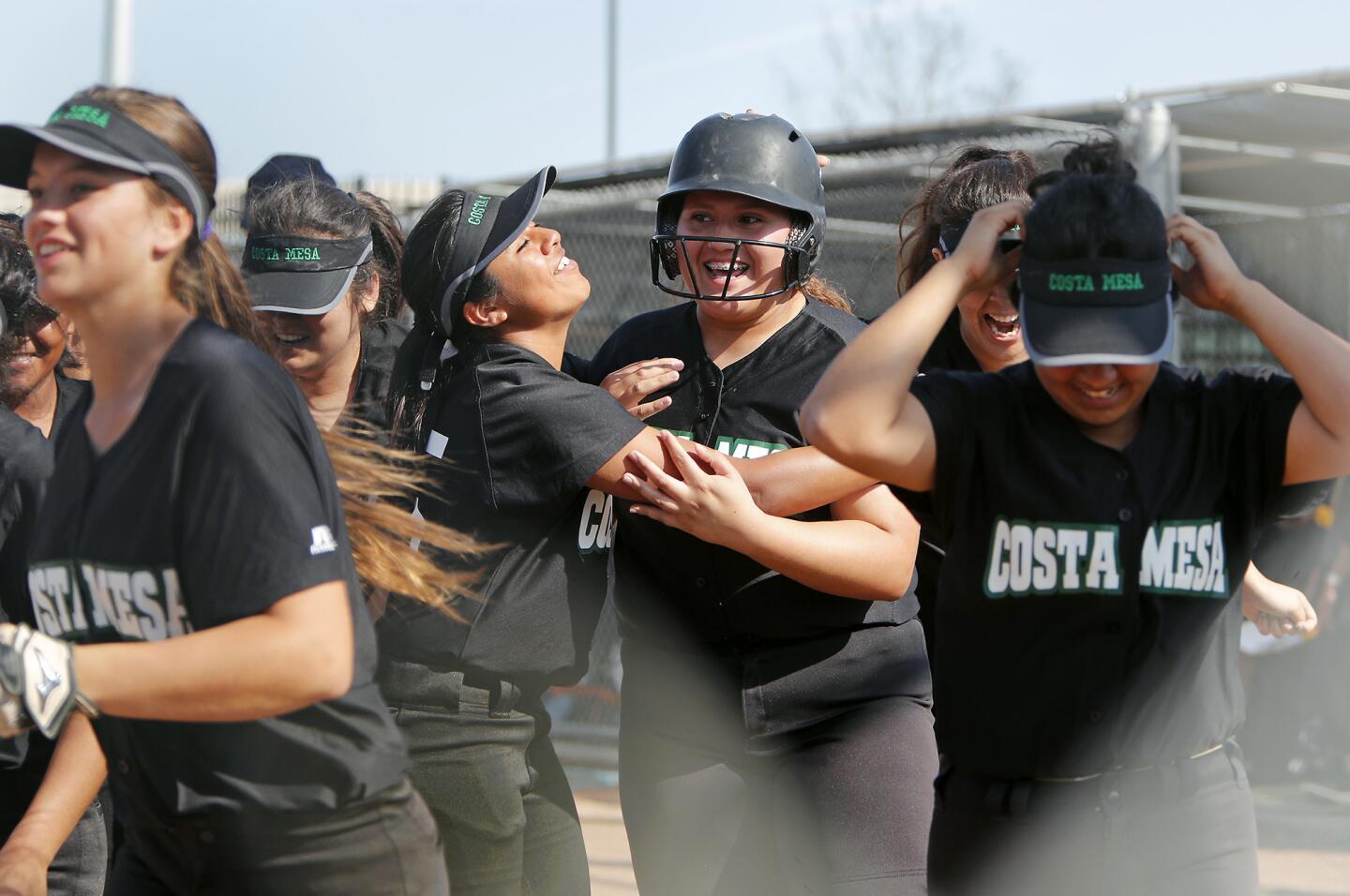 Vanessa Rodriguez, center, celebrates her solo homer with Costa Mesa High teammates in the second inning against Estancia in an Orange Coast League game at Costa Mesa on Friday.