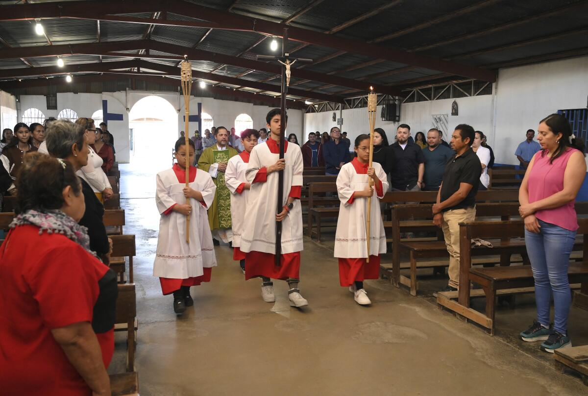 Altar servers lead the opening processional at a church in Costa Rica.