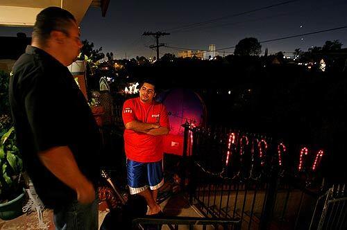 Fernando Diaz, left, talks with his nephew, Anthony Saucedo, in a darkened area of Boyle Heights. The streetlights have been out the last few months because thieves have made off with valuable copper wiring. Other problem spots include the east San Fernando Valley, Wilmington and a three-mile stretch of the Los Angeles River Bike Path between Los Feliz Boulevard and the L.A. Zoo.