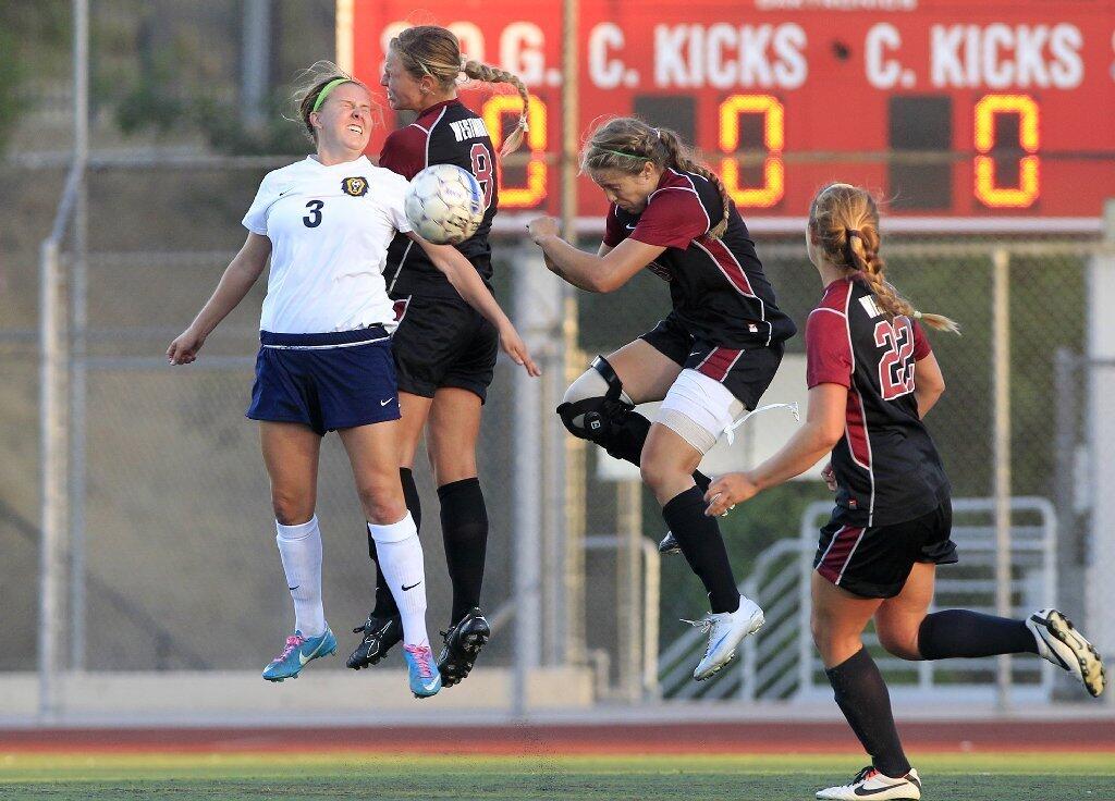 Vanguard's Jennifer Martin (3) goes up for the ball against Westmont's Sophie Judd, from left to right, Kaci Mexico and Carly Richardson during the second half at Biola University in La Mirada on Tuesday.