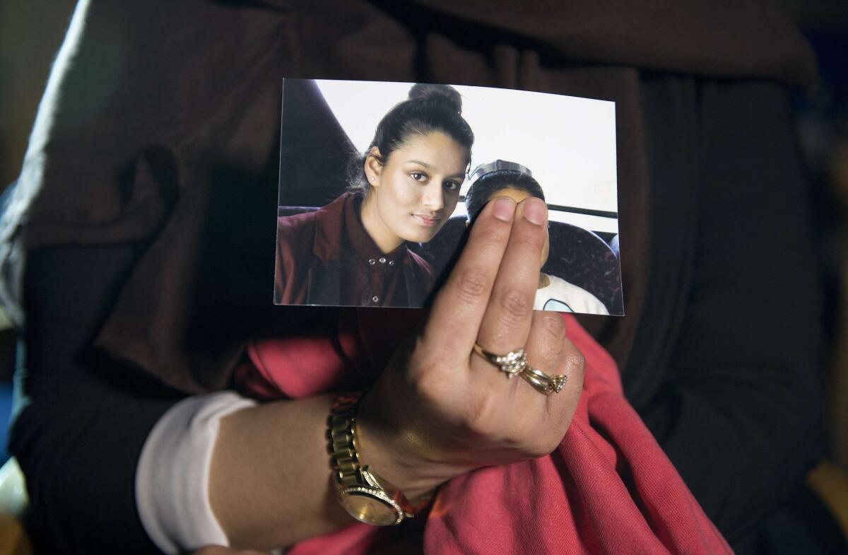 The sister of Shamima Begum holds a picture of the British teenager, one of three missing girls believed to have traveled to Syria to join Islamic State militants.