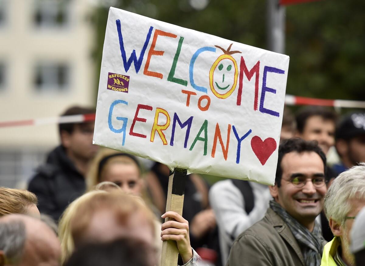 People welcome refugees on Sunday in the German city of Dortmund, where thousands of migrants arrived by trains.