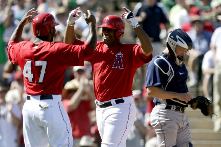 Angels' Vernon Wells, center, celebrates his two-run home run with Howie Kendrick.