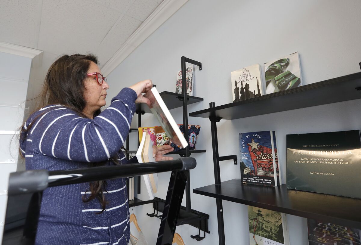 Sarah Rafael Garcia arranges books inside the new Libro Mobile bookstore location in Santa Ana.