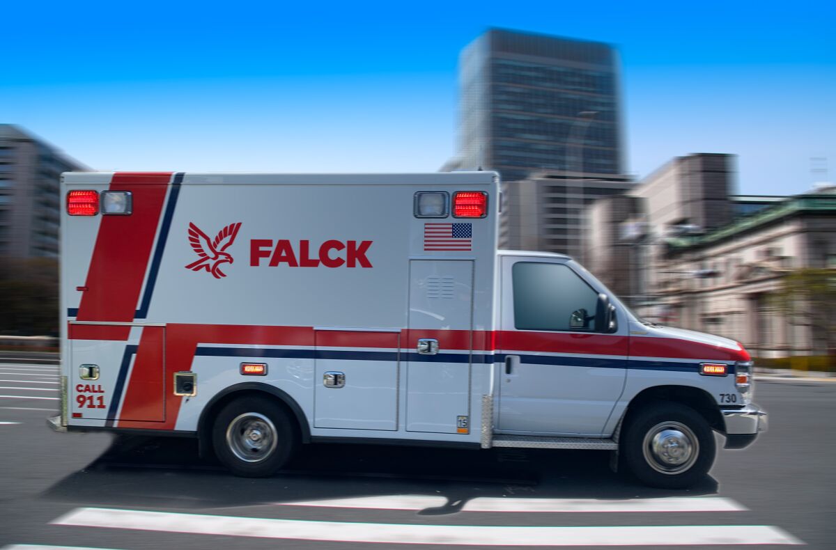 A Falck ambulance driving on a street