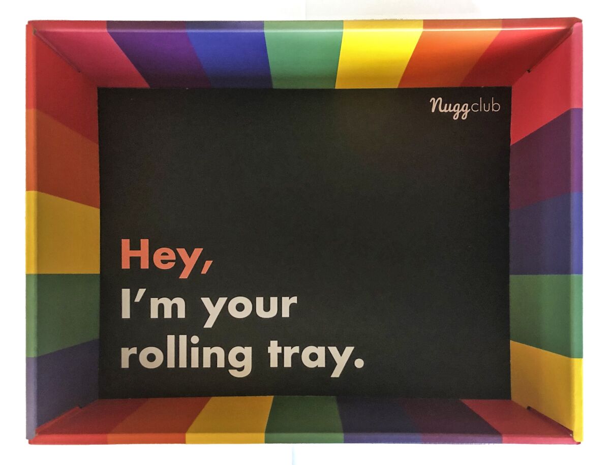 The inside of a rainbow-striped box printed with the message, "Hey, I'm your rolling tray."