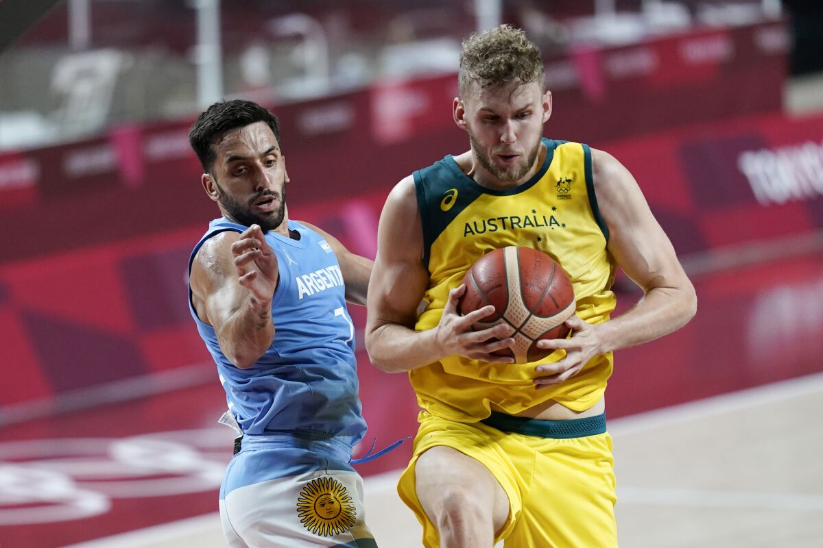 Australia's Jock Landale grabs a rebound ahead of Argentina's Facundo Campazzo, left, during a men's basketball quarterfinal round game at the 2020 Summer Olympics, Tuesday, Aug. 3, 2021, in Saitama, Japan. (AP Photo/Charlie Neibergall)