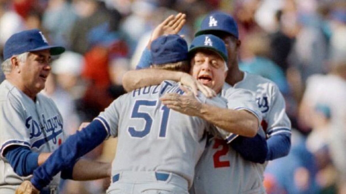 Los Angeles Dodger manager Tommy Lasorda, right, hugs Dodger relief pitcher Brian Holton (51), 