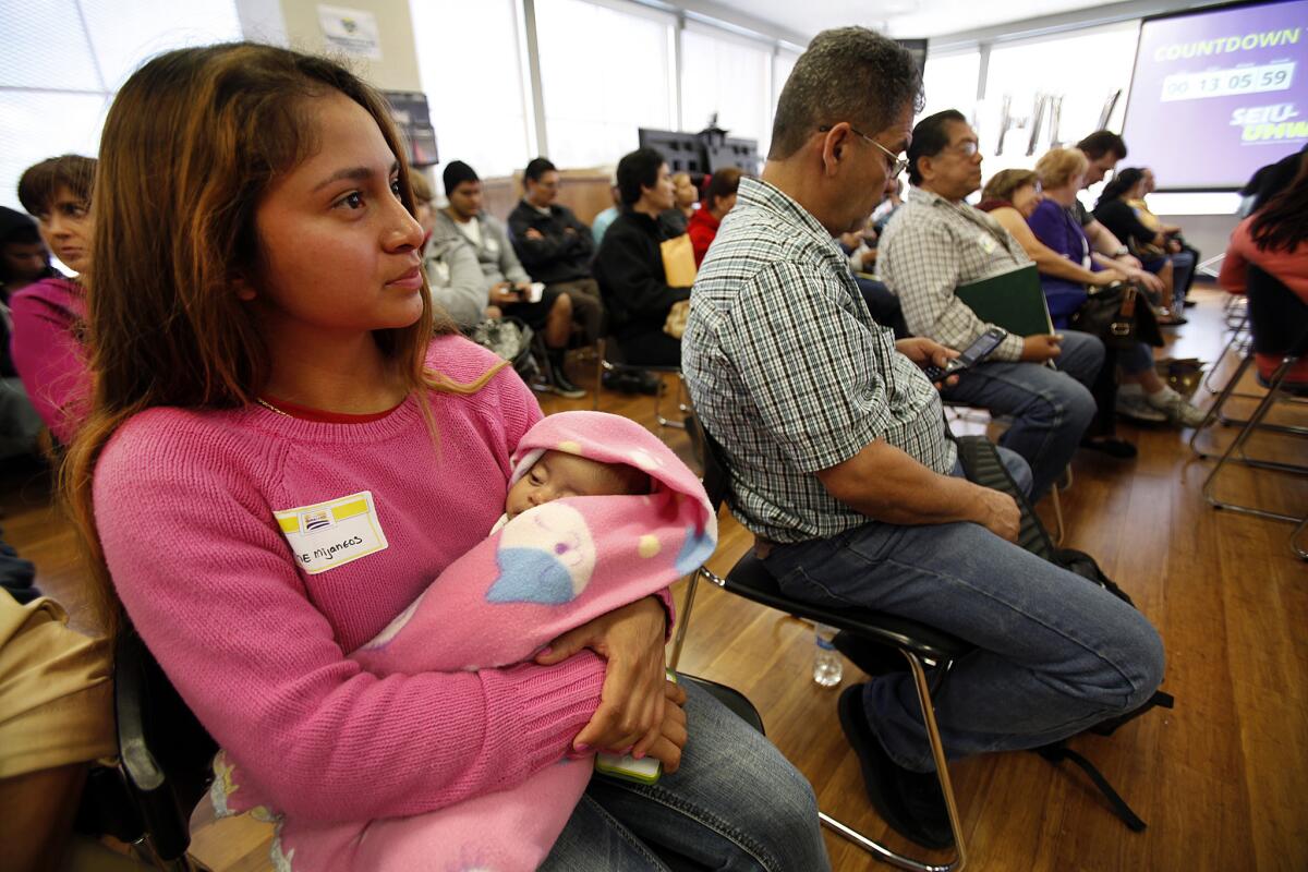 Aline Mijaneos waits with her 3-month-old daughter, Scarlett Valdez, for her turn to meet with an enrollment counselor about Obamacare at the offices of SEIU-United Healthcare Workers West in the City of Commerce.