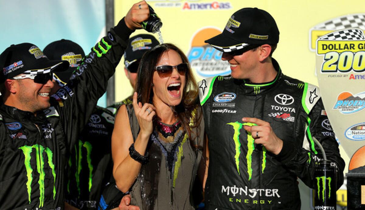 Nationwide driver Kyle Busch watches as his wife gets showered with Monster Energy drink during the celebration in Victory Lane on Saturday.