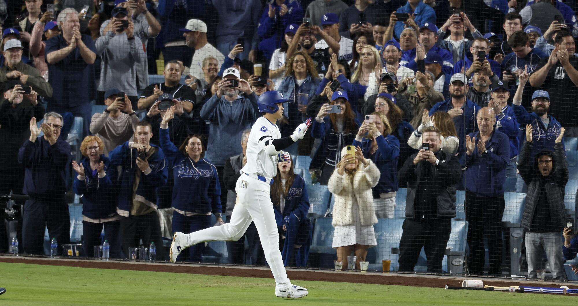 Fans applaud Shohei Ohtani as he heads to the dugout after hitting his first homer with the Dodgers.