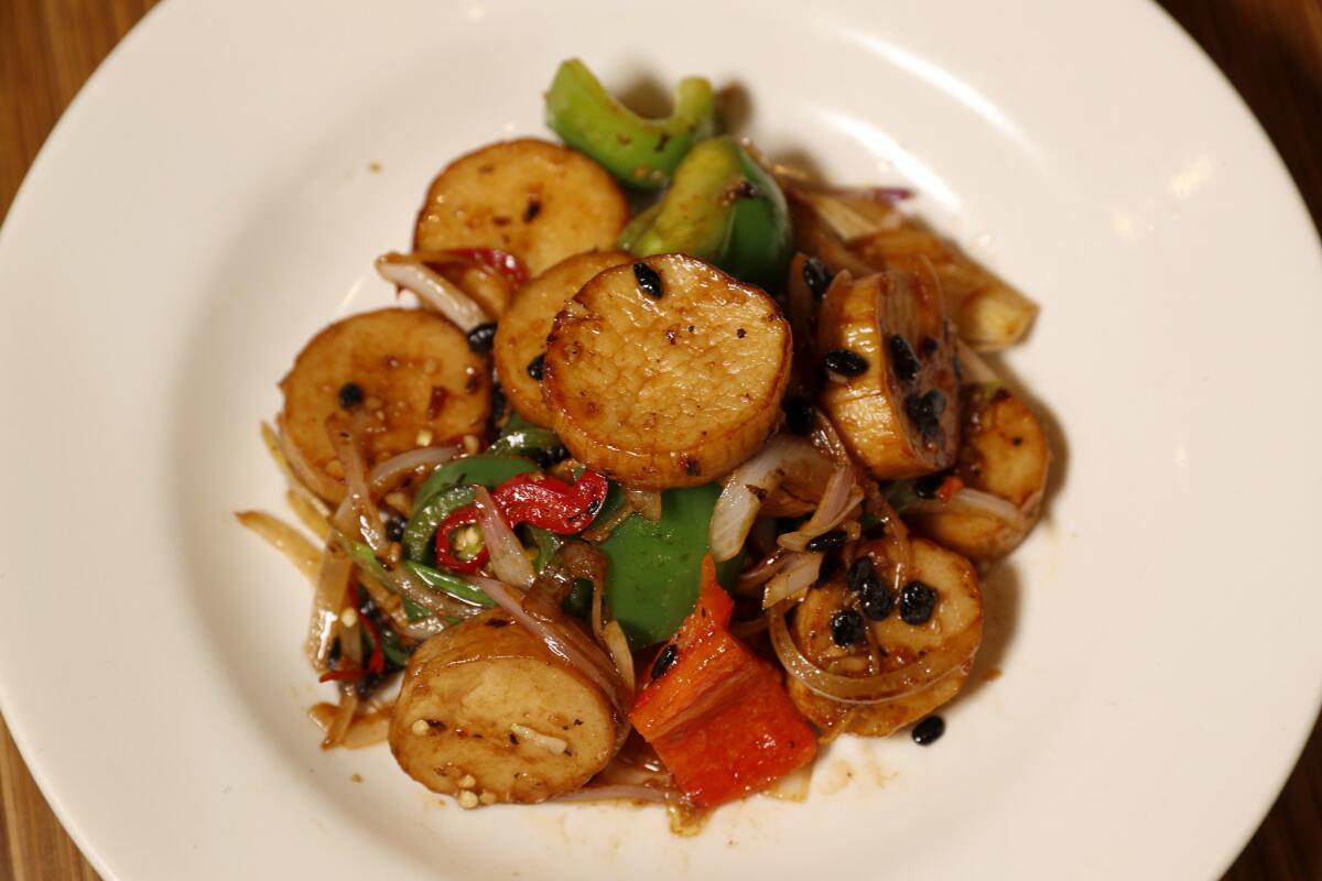 A plate of "scallops" in black bean sauce: sliced mushrooms stir fried with black beans in garlic sauce at Lotus Vegetarian Restaurant.