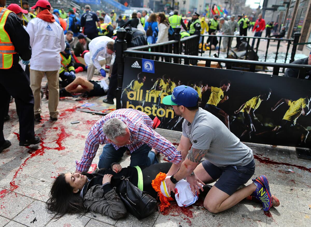 Sydney Corcoran is tended to at the finish line of the Boston Marathon on Monday. This photo ran in many newspapers across the nation Tuesday, but her identity was not immediately known.