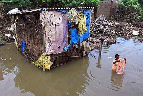 A woman washes clothes in floodwater on the outskirts of Vijayawada in Krishna district, about 155 miles from Hyderabad on Friday. The worst flooding in a century to hit the southern Indian states of Karnataka and Andhra Pradesh have killed hundreds of people, destroyed or washed away millions of acres of cropland and contaminated grain stocks in millions of homes.