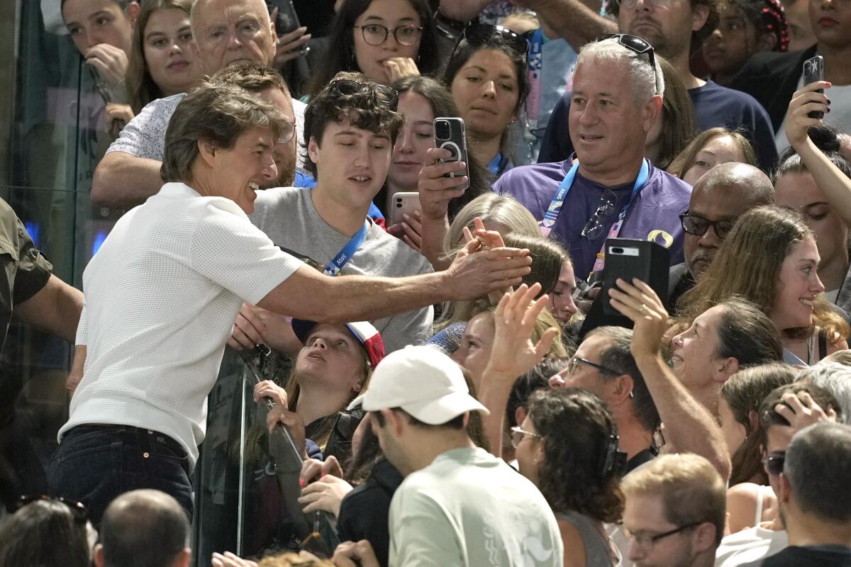 El actor Tom Cruise, izquierda, interactúa con los fans mientras 
