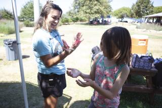 Tess Williams and Eliot Willson compare slime they made at the Toby Wells YMCA, the summer camp 